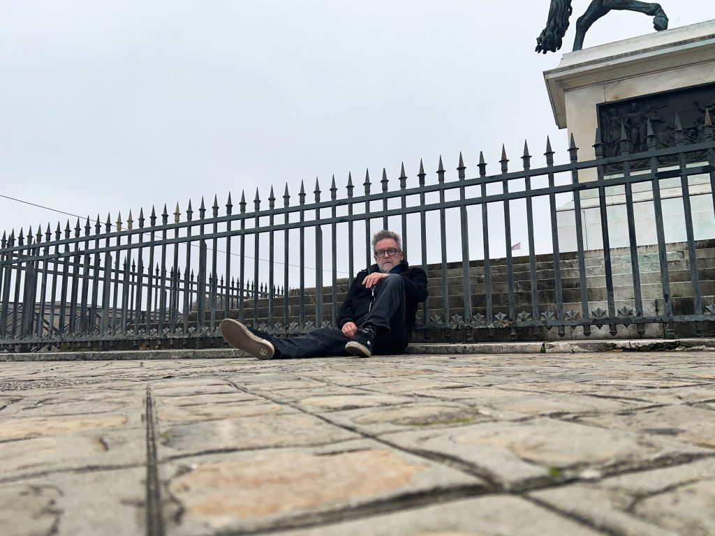 A modern-day photograph of Fredrik Hagblom resting against the cast iron fence on Pont Neuf, recreating the spot where workers appeared in Daguerre's historic early photograph.