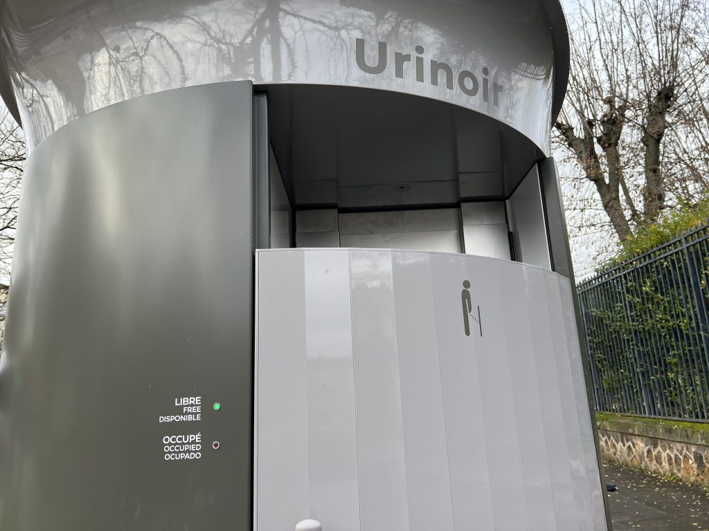 A modern public pissoir in Paris, showcasing sleek and functional design in an urban setting.