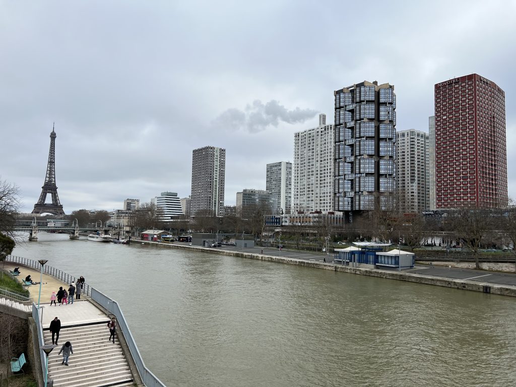 The full scope of the Front de Seine project, with the Seine River in the foreground and the Eiffel Tower in the background.